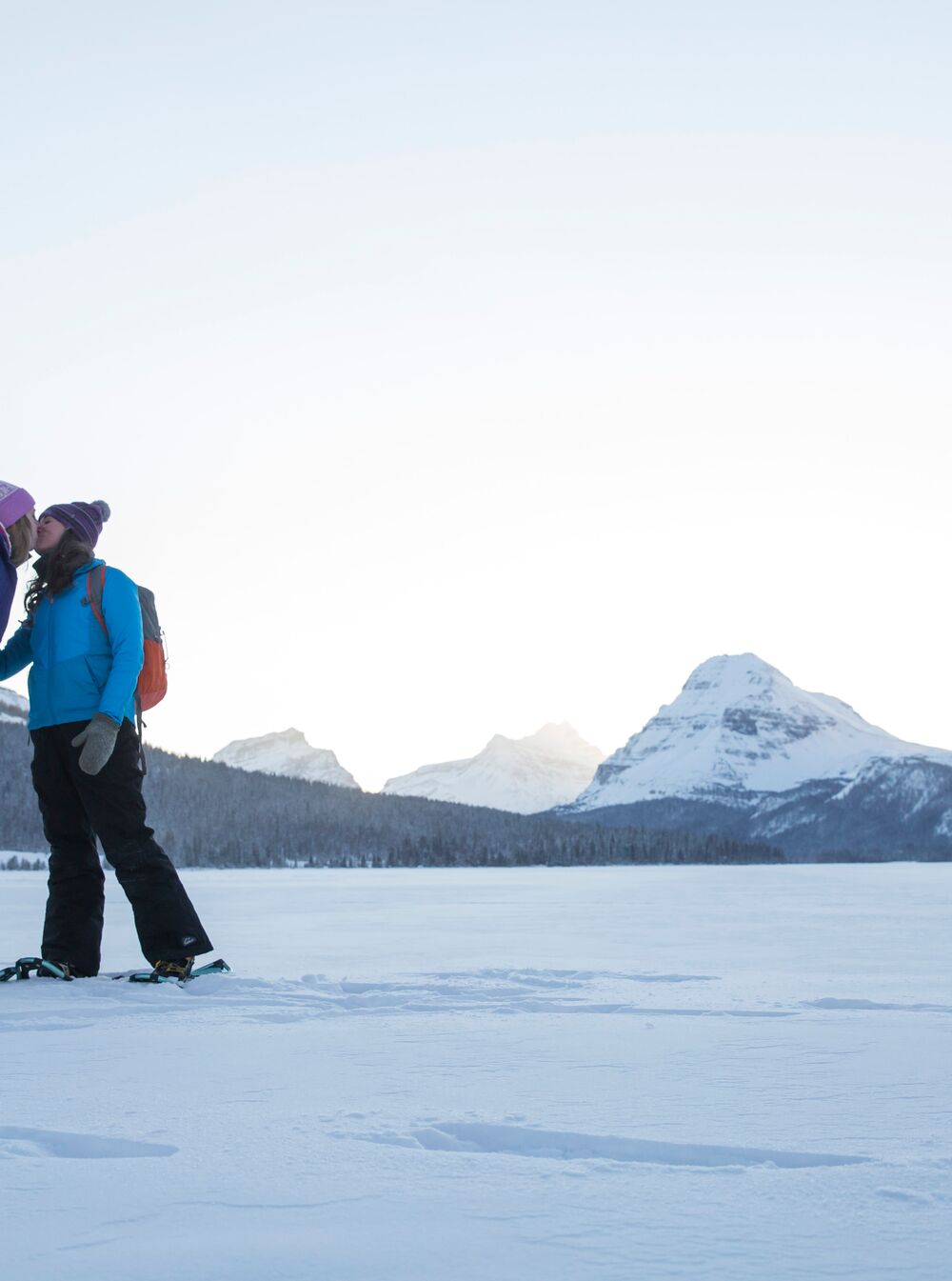 Two snowshoers share a kiss on Bow Lake on the Icefield Parkway in Banff National Park.
